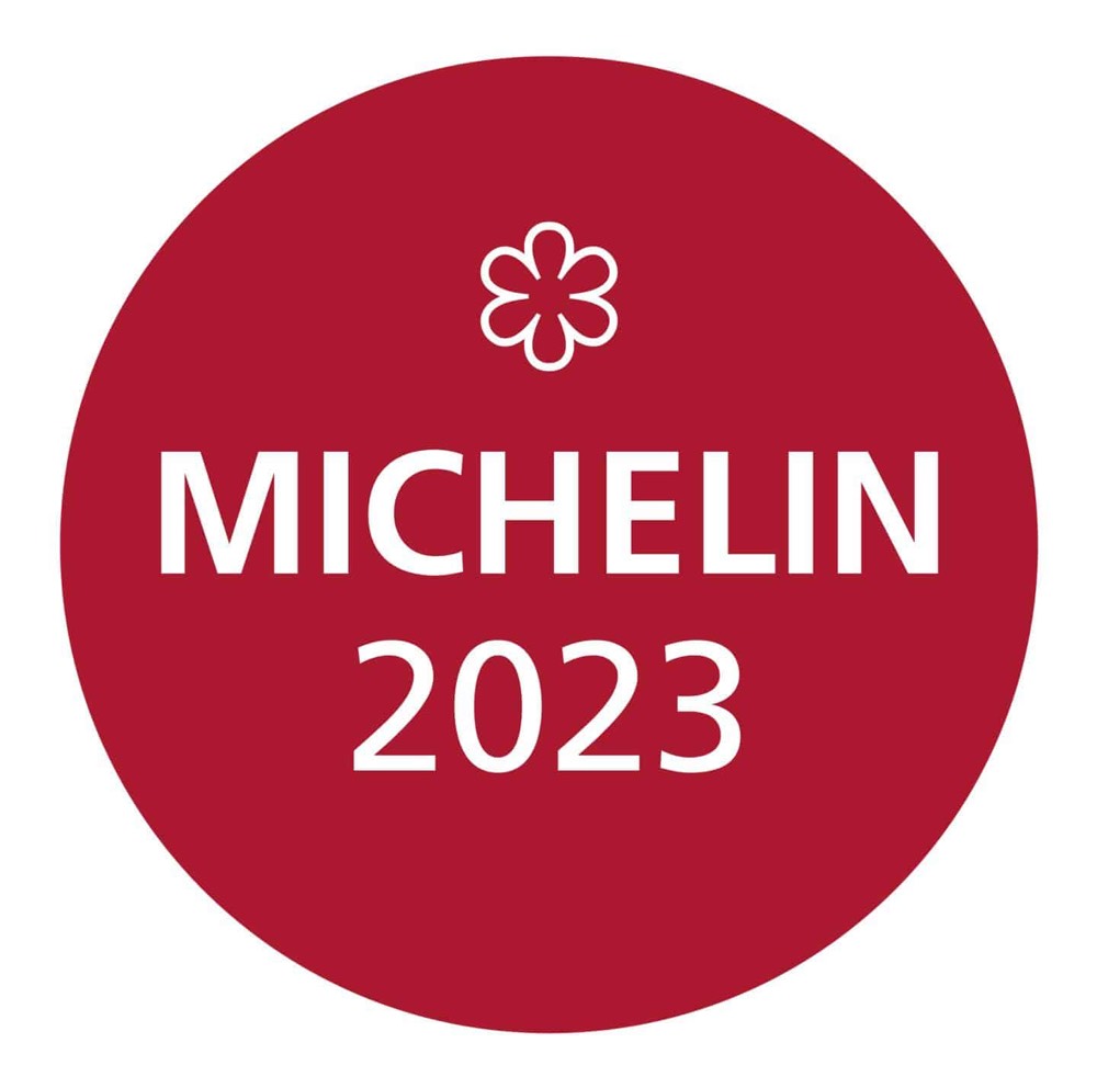 A red circular badge with a white Michelin star symbol at the top