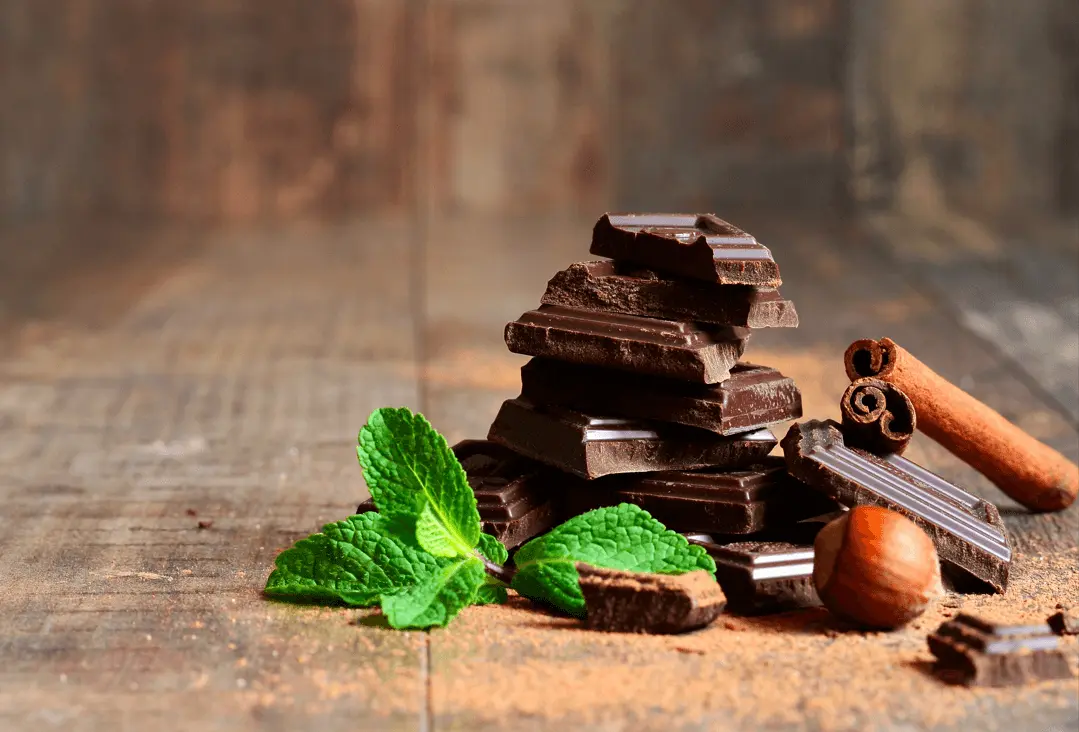 Dark chocolate bits on a wooden table closeup view